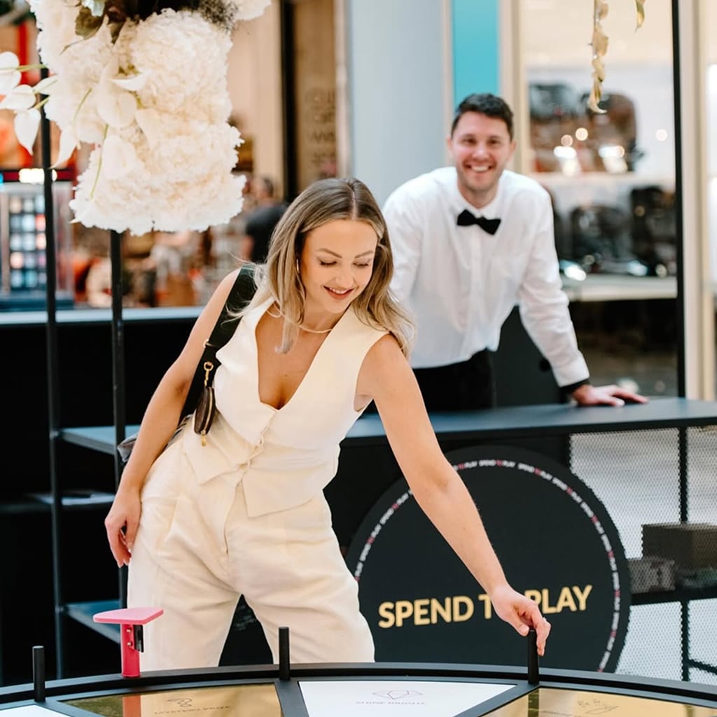 Woman spinning a wheel of fortune installation